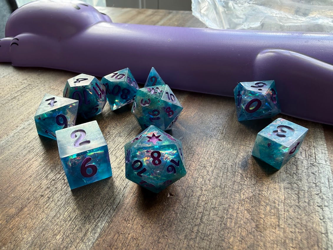 Set of blue dice with star patterns on a wooden surface