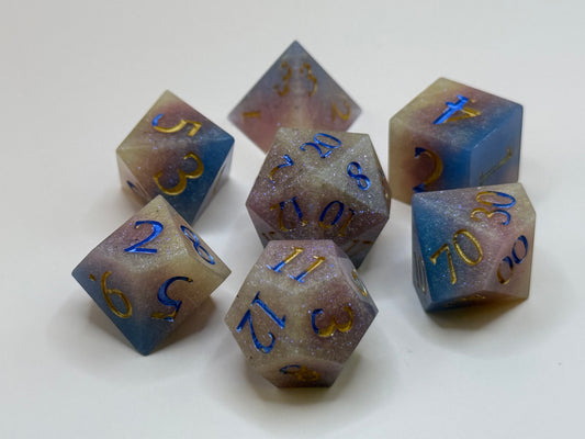 Set of polyhedral dice with blue and purple colors and gold numbers on a white background