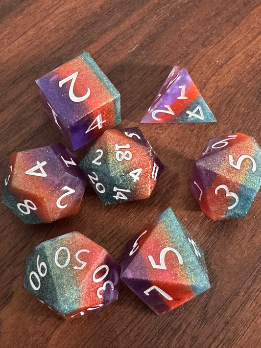 polyhedral sharp-edge, a set of seven in green, orange and purple on a wood table. Numbers are inked in white.