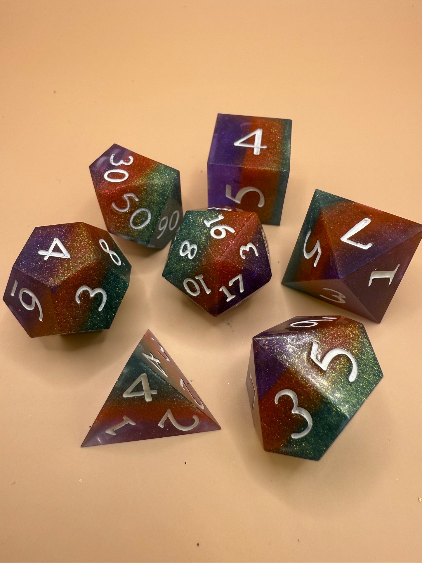 Set of colorful polyhedral dice on a beige background
