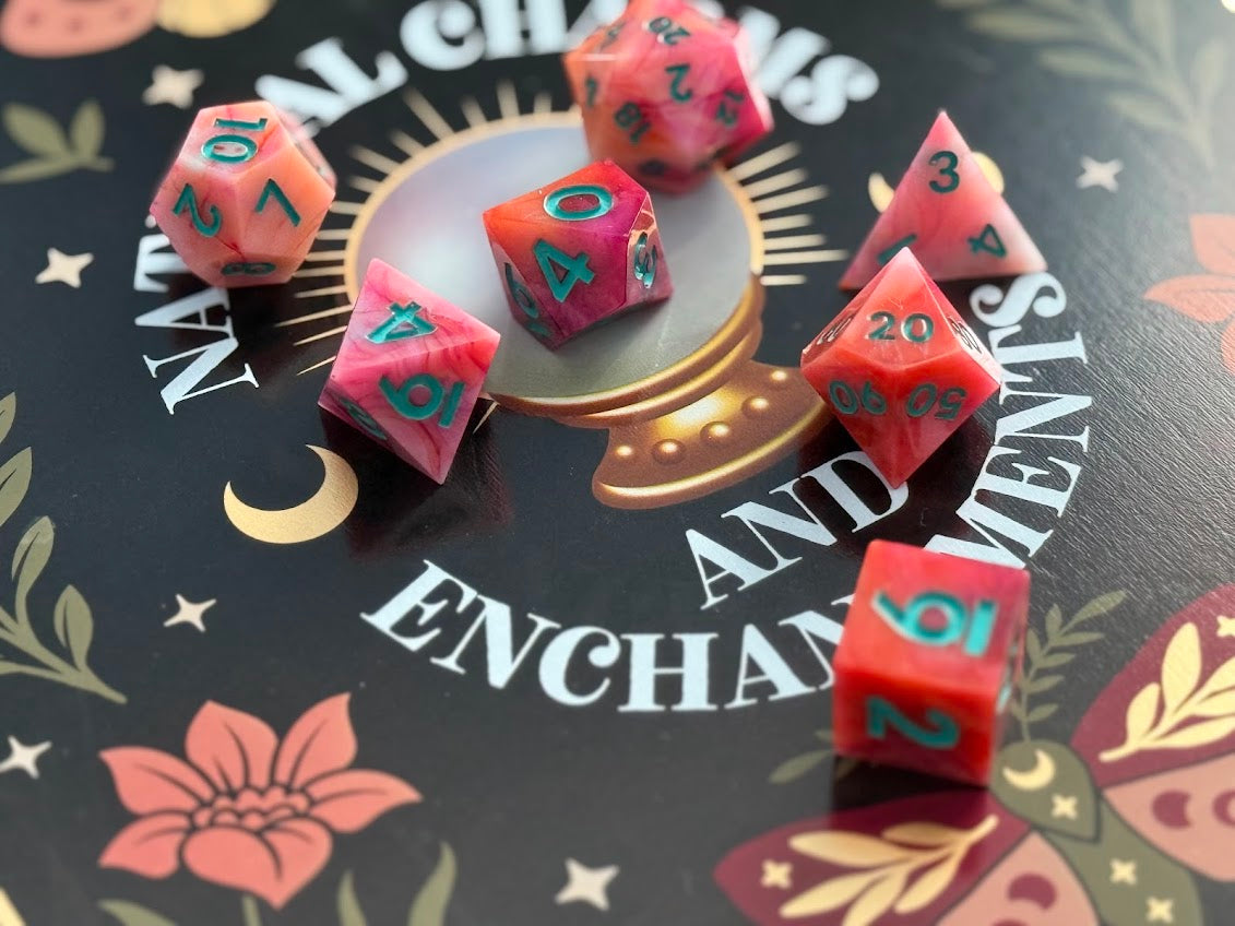 Pink polyhedral dice with green numbers on a decorative background