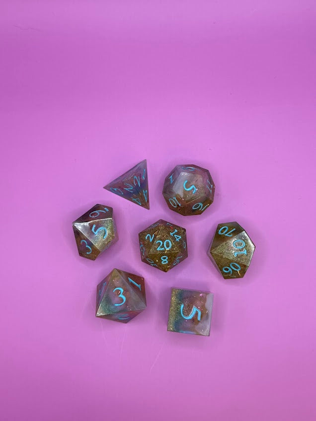 Set of metallic polyhedral dice on a pink background