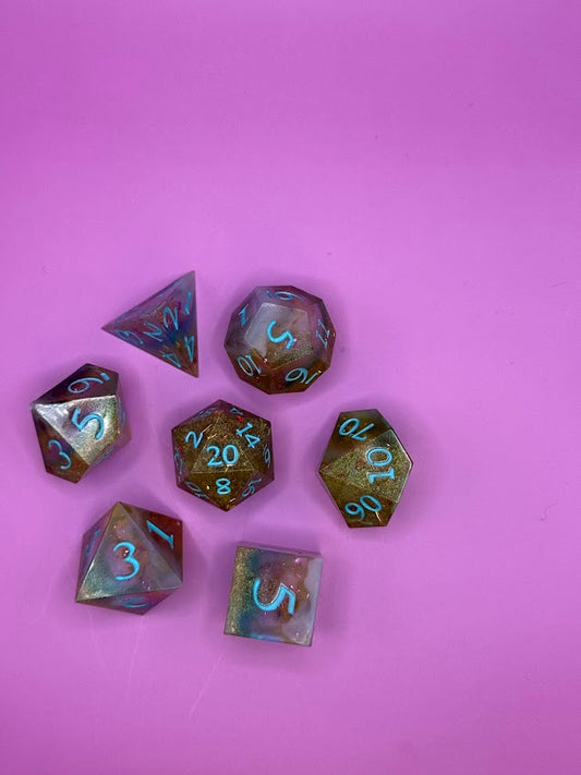 Set of dice with metallic sheen on a pink background