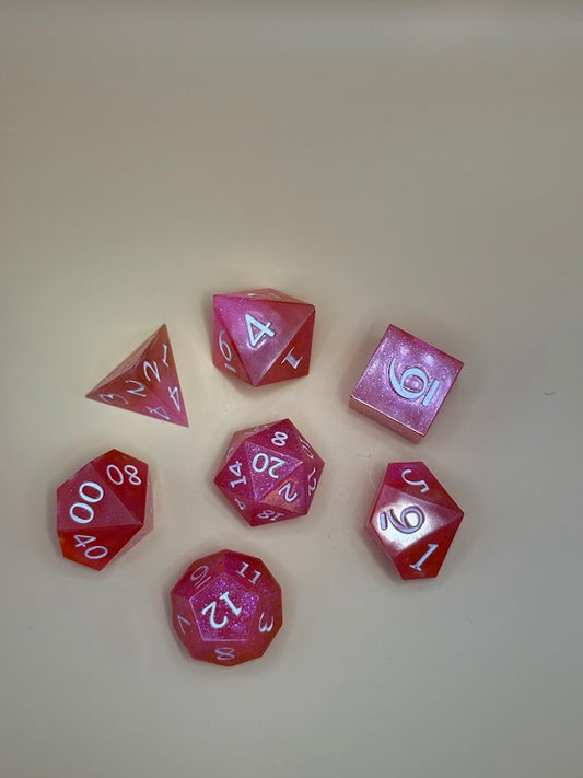 Set of pink polyhedral dice on a beige background