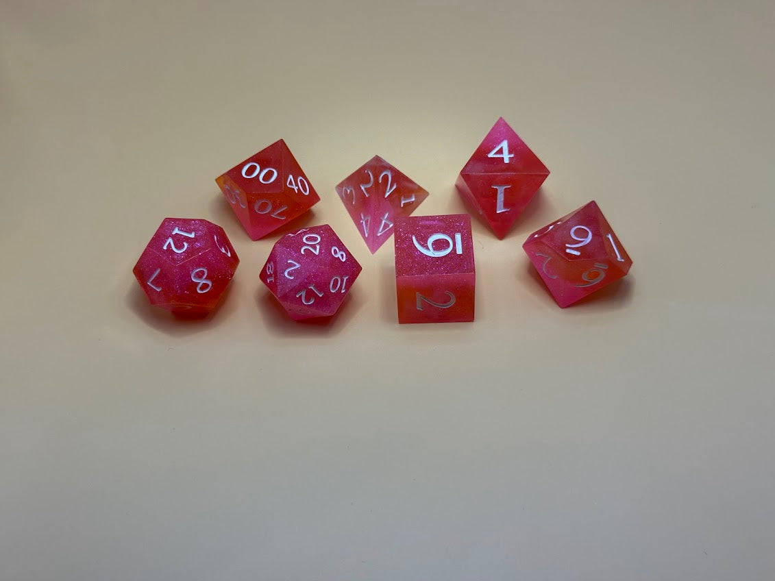 Set of pink polyhedral dice on a beige background