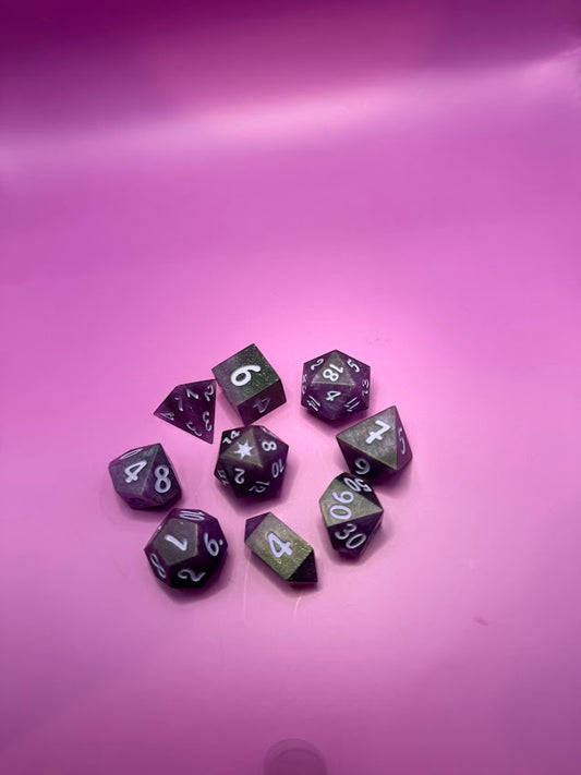 Purple polyhedral dice set on a pink background