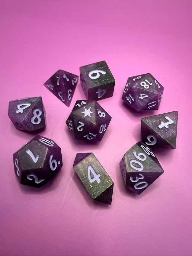Purple polyhedral dice set on a pink background
