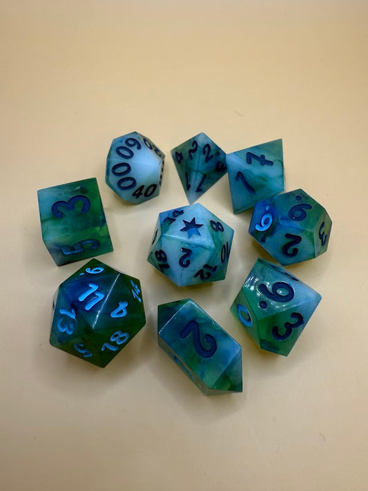 Set of green and blue polyhedral dice on a beige background