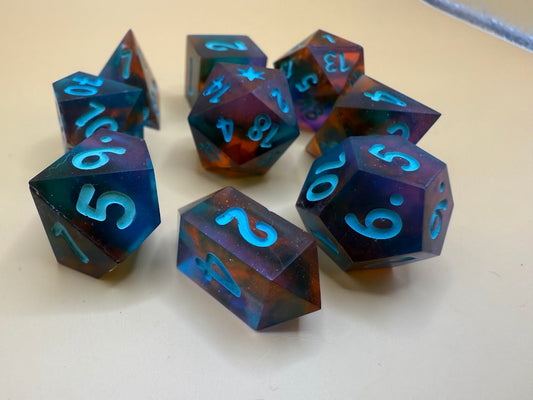 Set of colorful polyhedral dice with blue numbering on a light background