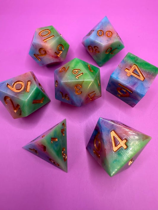 Set of colorful polyhedral dice with numbers on a pink background