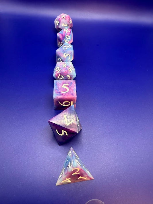 Set of colorful polyhedral dice with a clear triangle-shaped bag on a blue background