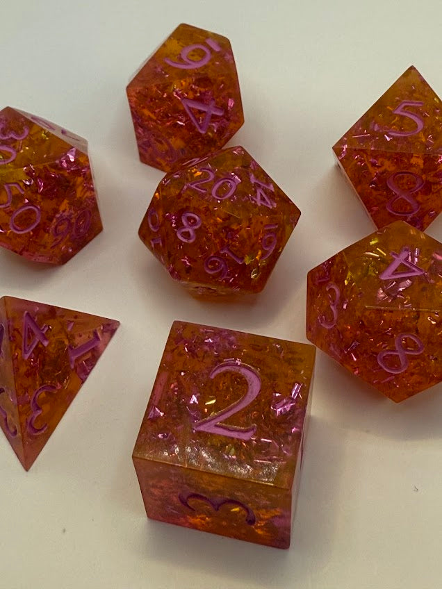 Set of polyhedral dice with orange and purple colors on a white background