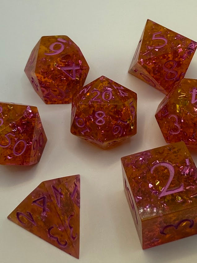 Set of polyhedral dice with orange and purple colors on a white background