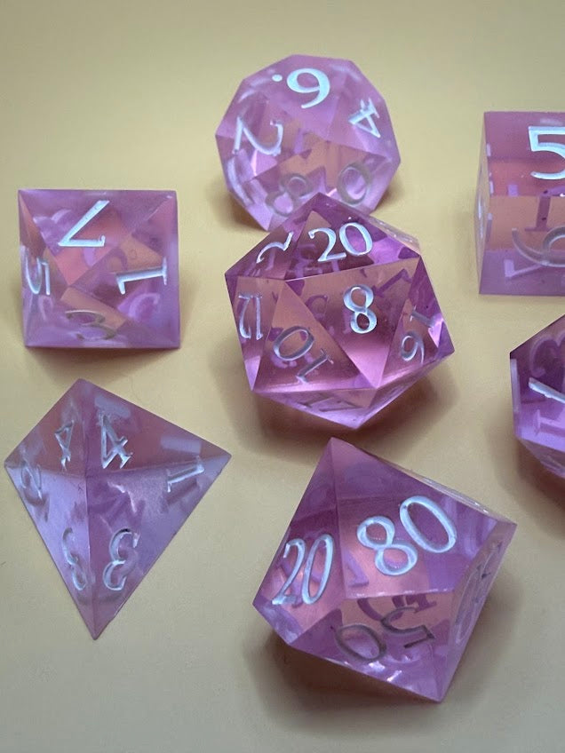 Set of purple polyhedral dice on a beige background