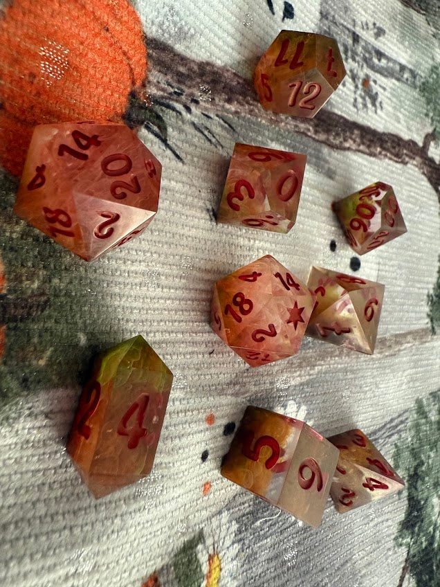 Set of polyhedral dice with red numbers on a textured surface