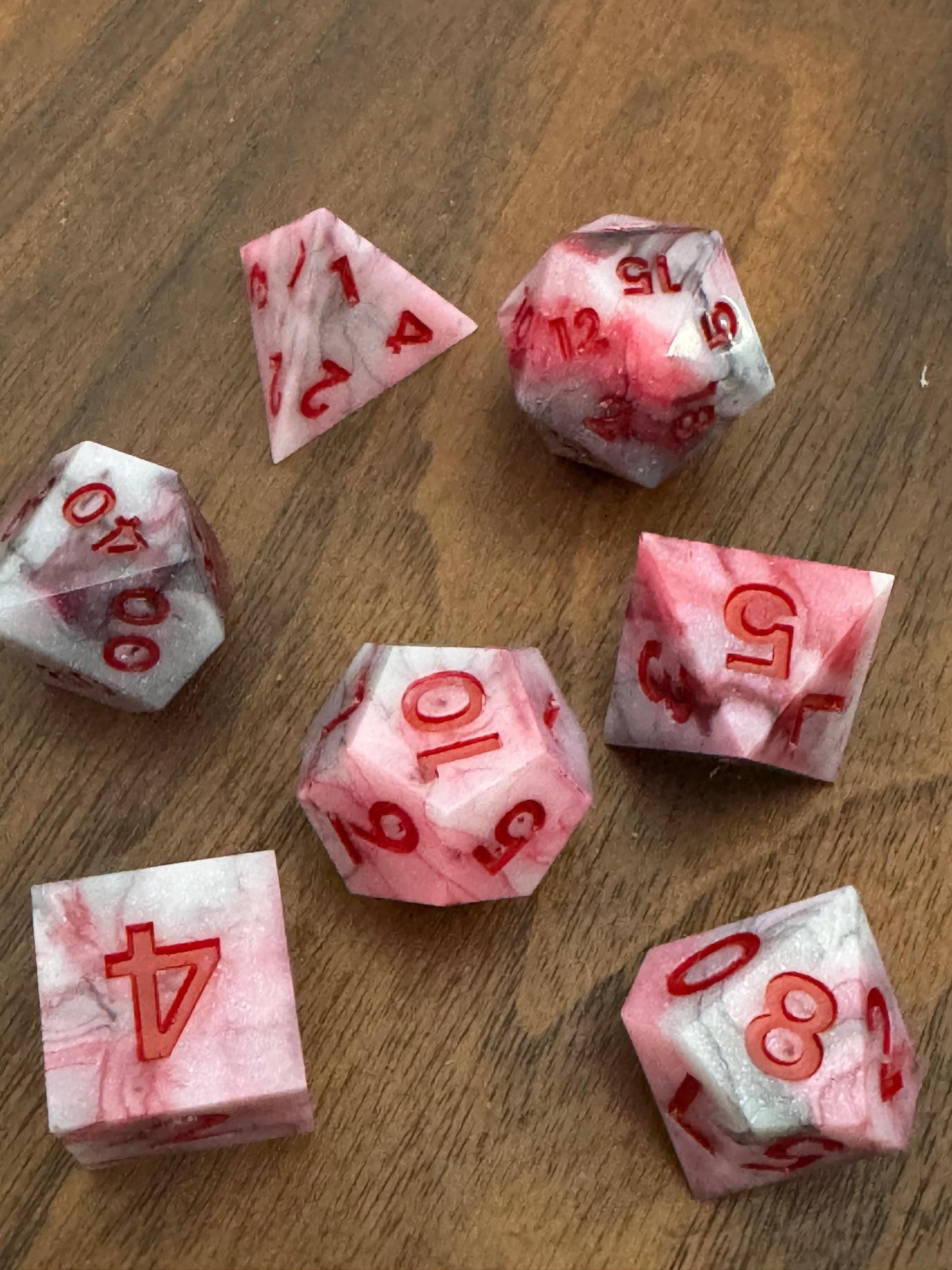 Set of red and black dice with red numbers on a wood background