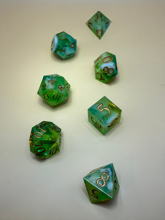 Green polyhedral dice with gold numbers on a beige background