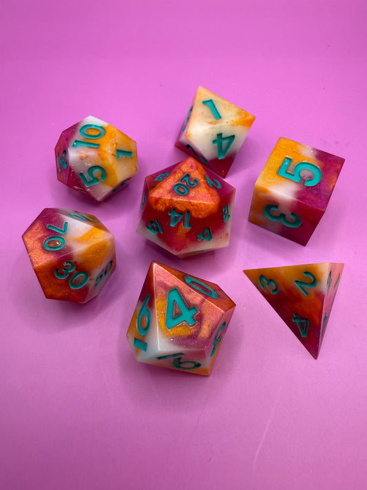 Colorful polyhedral dice set on a pink background