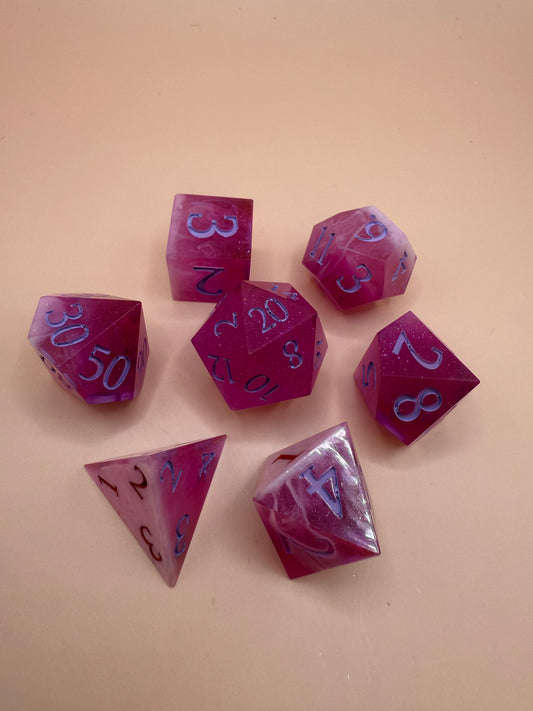 Set of pink and white polyhedral dice on a beige background