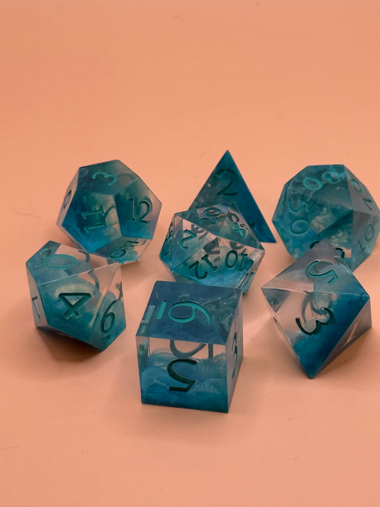 Set of blue and clear polyhedral dice on a peach background