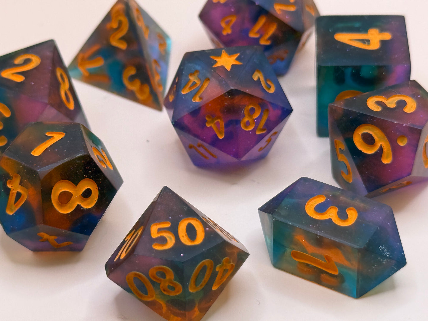 Set of polyhedral dice with orange numbers on a white background