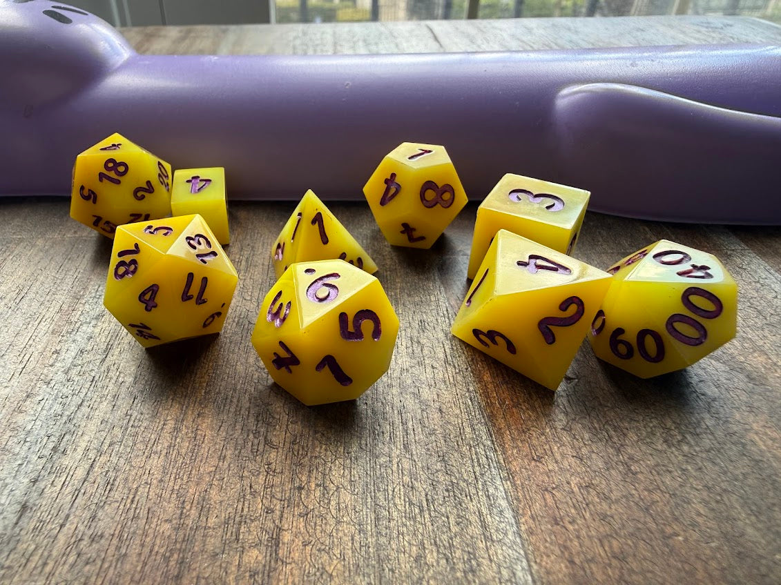 Yellow dice with black numbers on a wooden surface