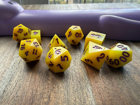 Yellow dice with black numbers on a wooden surface