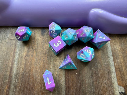 Set of purple and blue polyhedral dice on a wooden surface