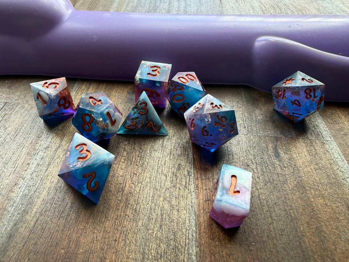 Set of dice with blue and purple gradient on a wooden surface