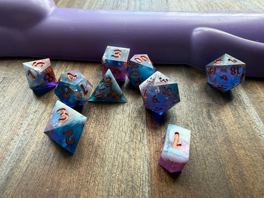 Set of dice with blue and purple gradient on a wooden surface