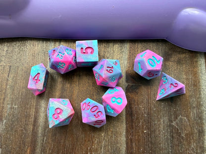 Pink and blue dice with numbers on a wooden surface
