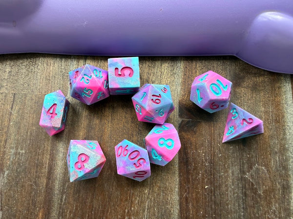 Pink and blue dice with numbers on a wooden surface
