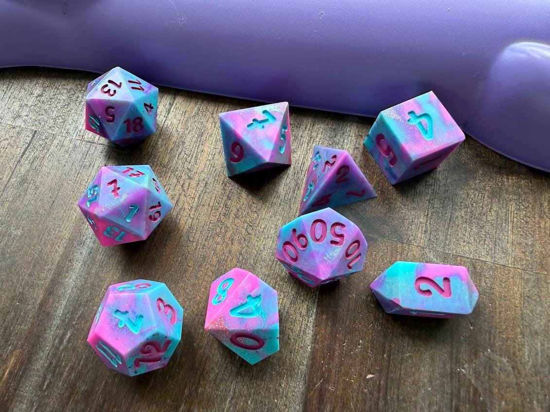 Set of pink and blue dice with numbers on a wooden surface