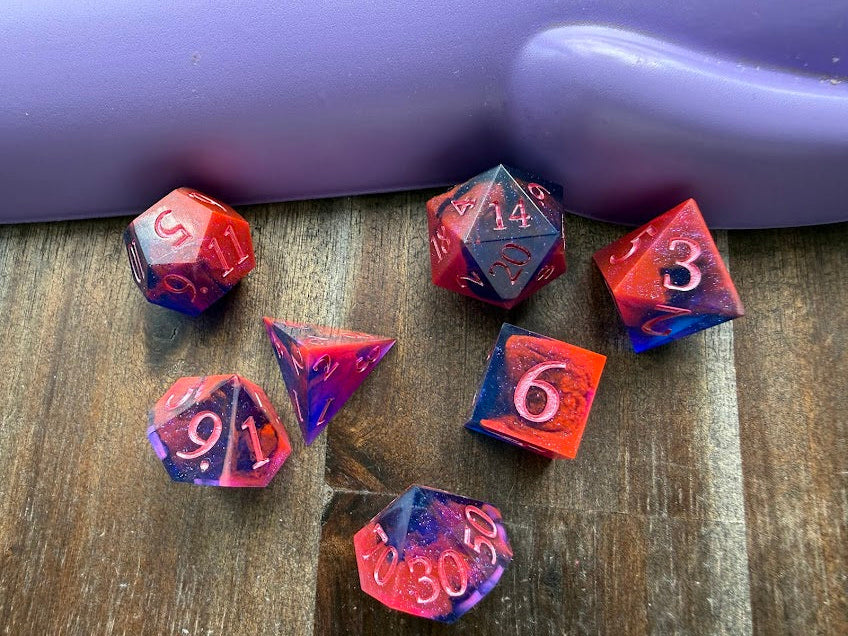 Set of colorful polyhedral dice on a wooden surface with a purple background