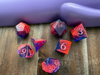 Set of colorful polyhedral dice on a wooden surface with a purple background