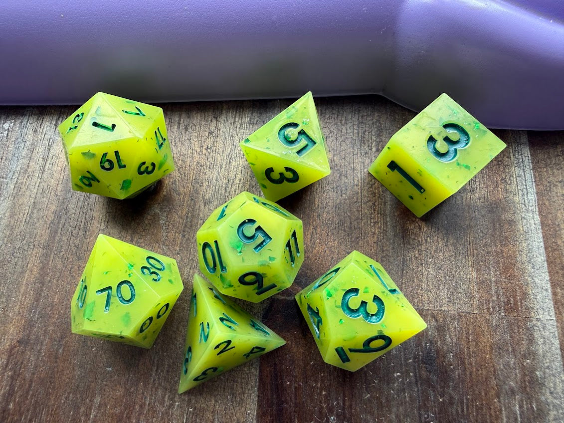 Set of green polyhedral dice with numbers on a wooden surface