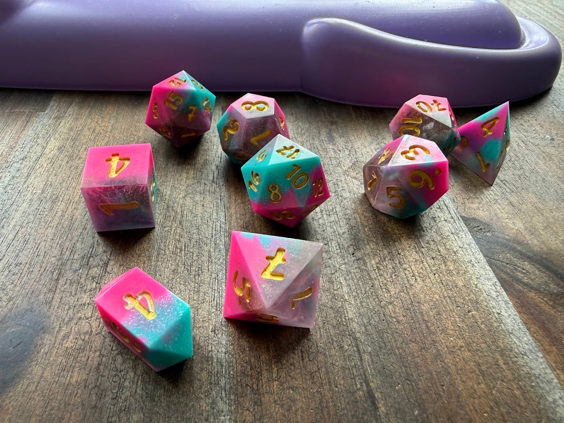 Wooden dice with numbers on a wooden surface with a purple object in the background