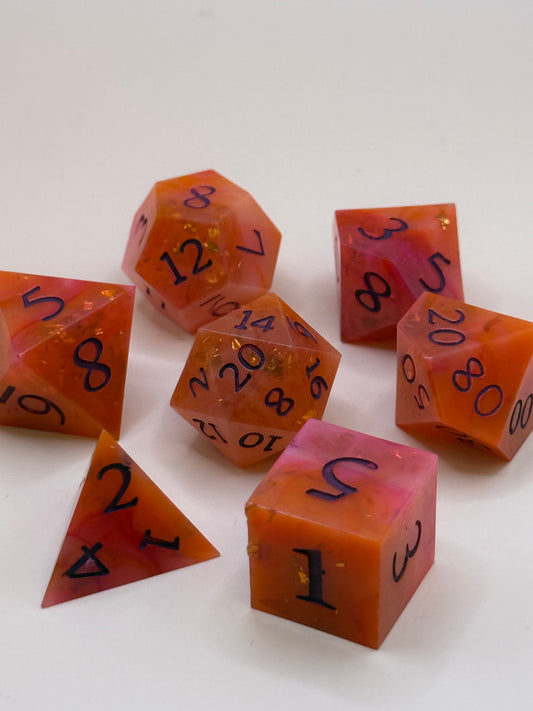 A set of 7 orange and red, swirled polyhedral dice on a table. 