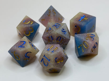 Set of polyhedral dice with blue and gold numbers on a white background