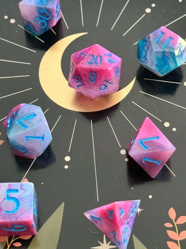 Colorful polyhedral dice set on a black background with star and moon designs