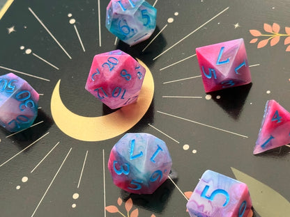 Colorful polyhedral dice on a starry background with a crescent moon.