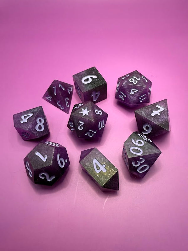 Set of purple tabletop RPG dice with white numbers on a pink background
