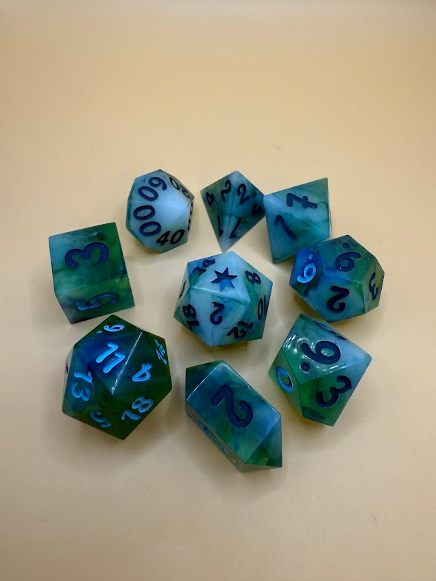 Set of green and blue polyhedral dice on a beige background