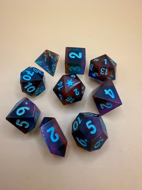 Handcrafted RPG dice set in blue and red with bright blue numbers on a tan background
