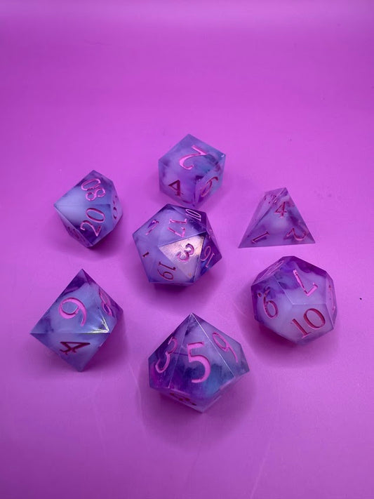 Set of purple and clear polyhedral dice on a pink background