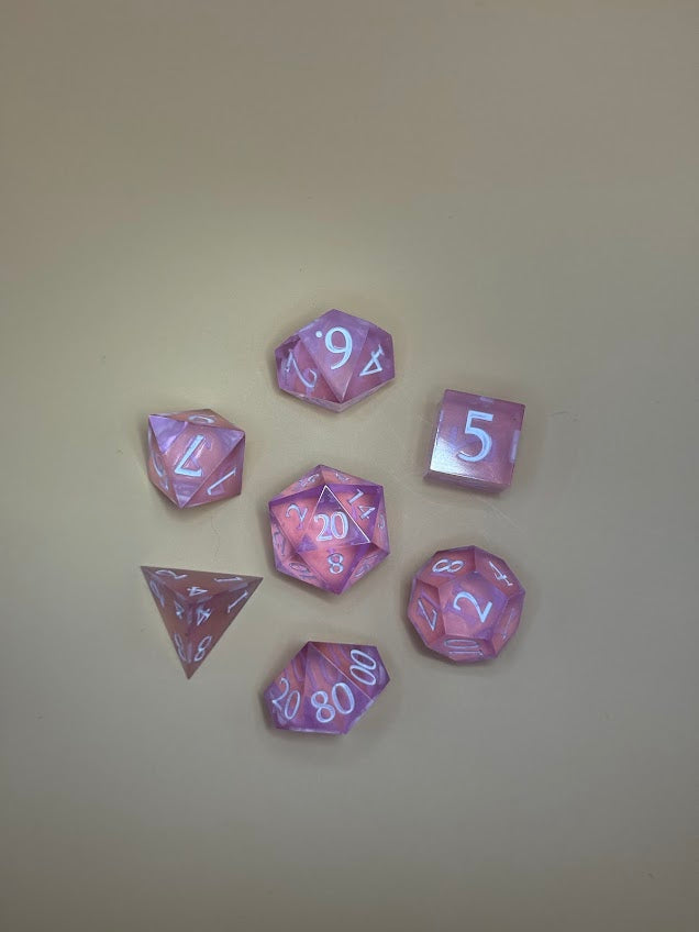 Set of purple polyhedral dice on a beige background