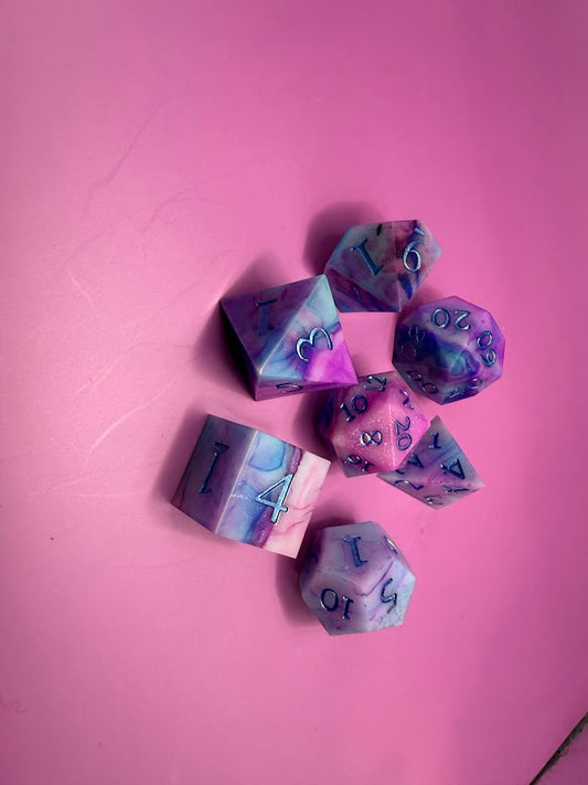 Set of colorful polyhedral dice on a pink background