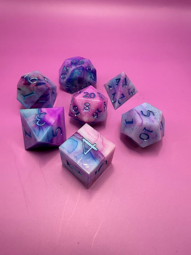 Set of colorful polyhedral dice on a pink background