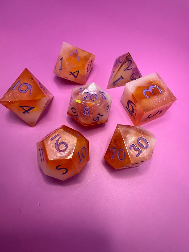 Set of polyhedral dice with purple numbers on a pink background