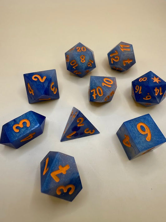 Blue polyhedral dice with orange numbers on a white background
